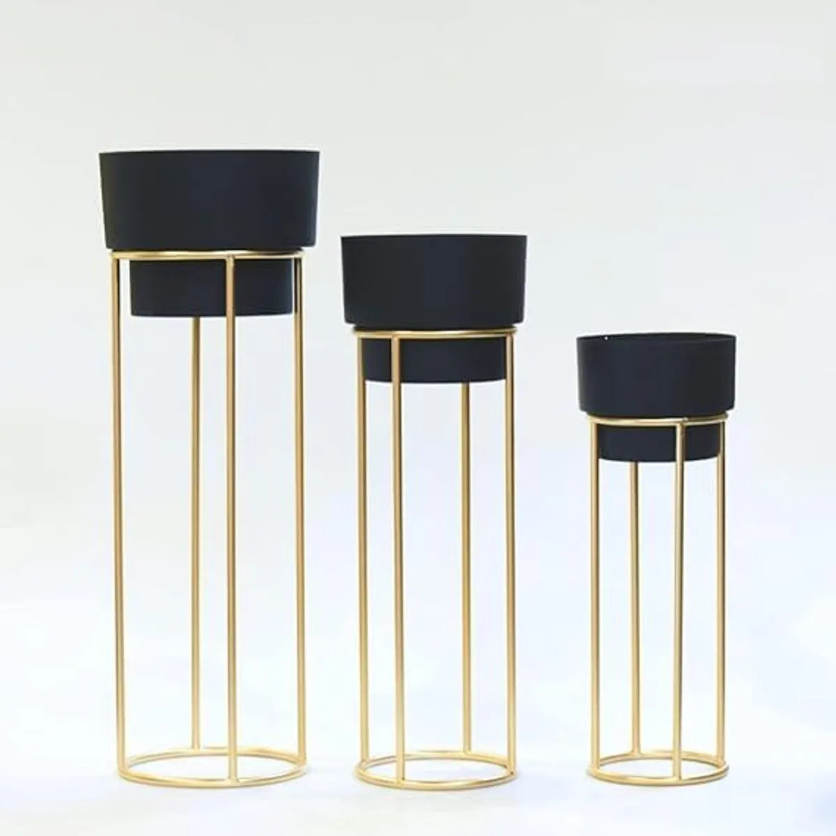 Golden metal floor-standing plant stand with a black pot