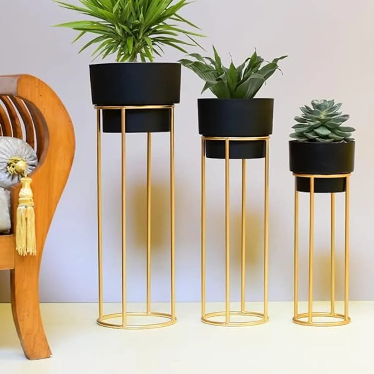 Golden metal floor-standing plant stand with a black pot